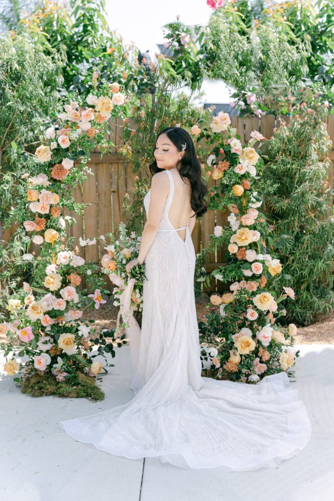 Bridal portraits in front of garden inspired ceremony arch