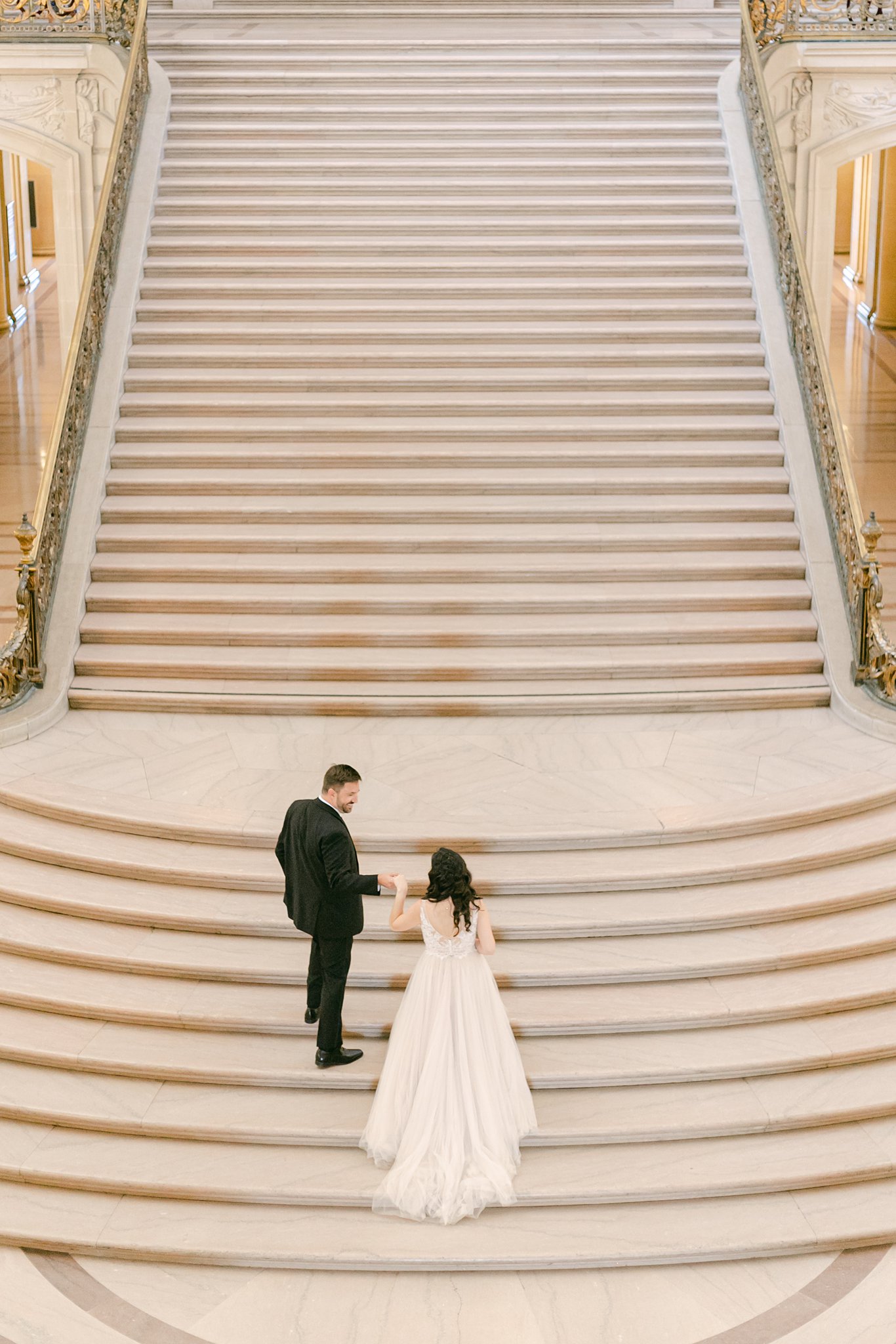 elopement bride and groom walking up the steps in San Francisco City Hall
